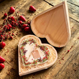 Large heart-shaped mulled wine scented candle with detailed view of star anise and red berry decorations in heart gift box